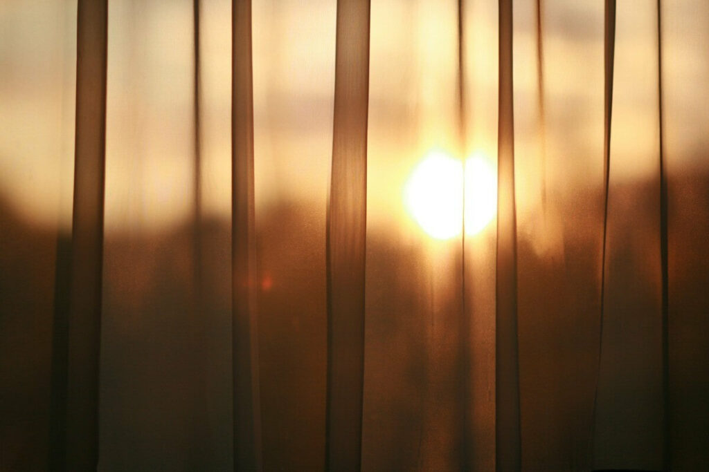 солнце просвечивает через шторы